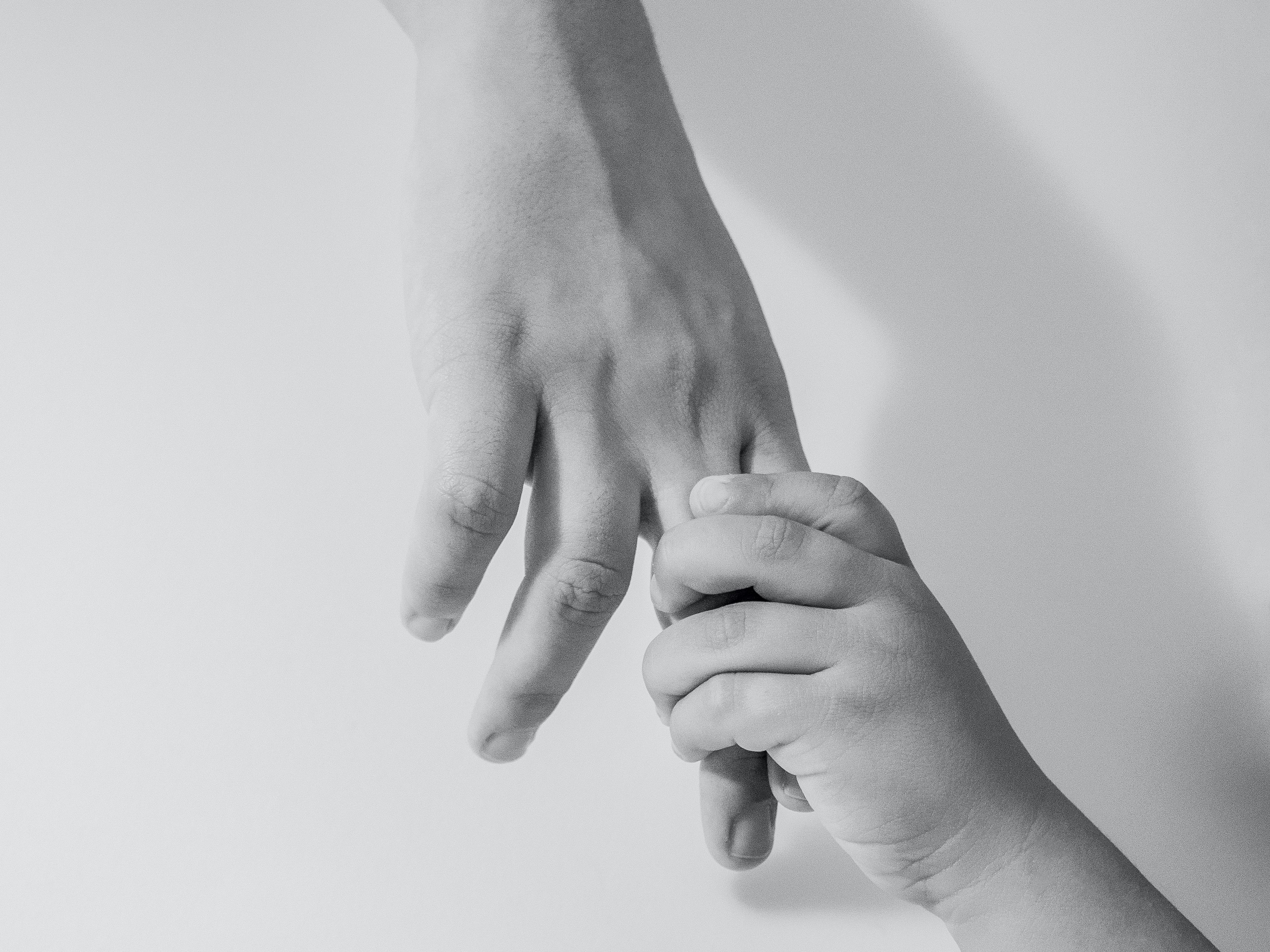 a photo of a child holding a father's hand, representing trust